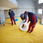 grouo of workera installing underfloor heating and colling in modern home