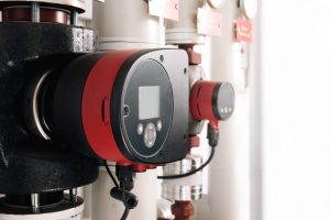 Smart circulator pump for residential and commercial heating or cooling. Used to adjust or changing settings or inspection of heating system. Plumbing or heating background. Selective focus.