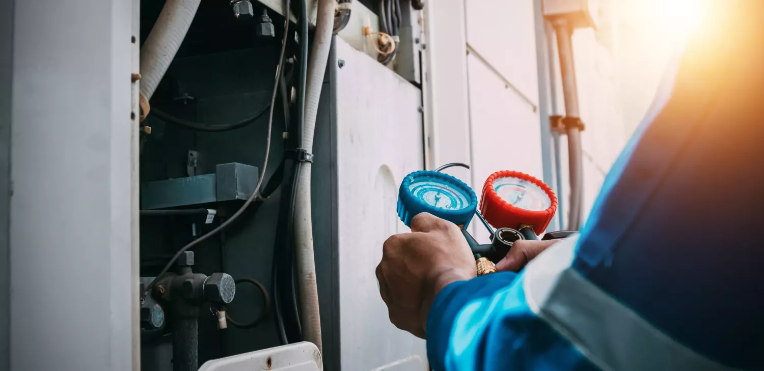 Technician is checking air conditioner refrigerant leak.