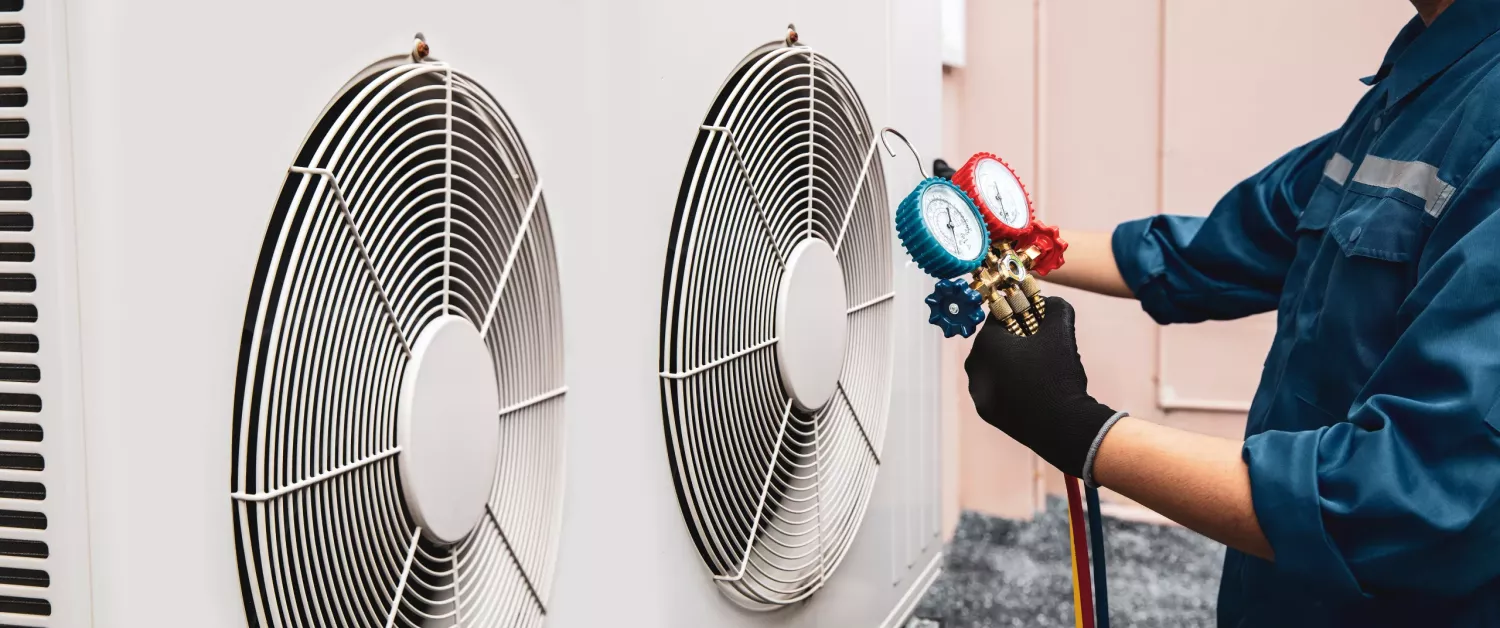 Heat and Air Conditioning, HVAC system service technician using measuring manifold gauge checking refrigerant and filling industrial air conditioner after duct cleaning maintenance outdoor compressor.