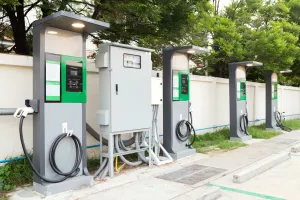 fast electric vehicle car charger with cable supply plugged and power supply box at EV station sites. EV car charging station in car park at supermarket ready to serve future automotive and city life.
