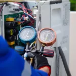 air conditioner technician using manifold gauge checking refrigerant for filling home air conditioning and air duct cleaning and maintenance outdoor compressor unit.