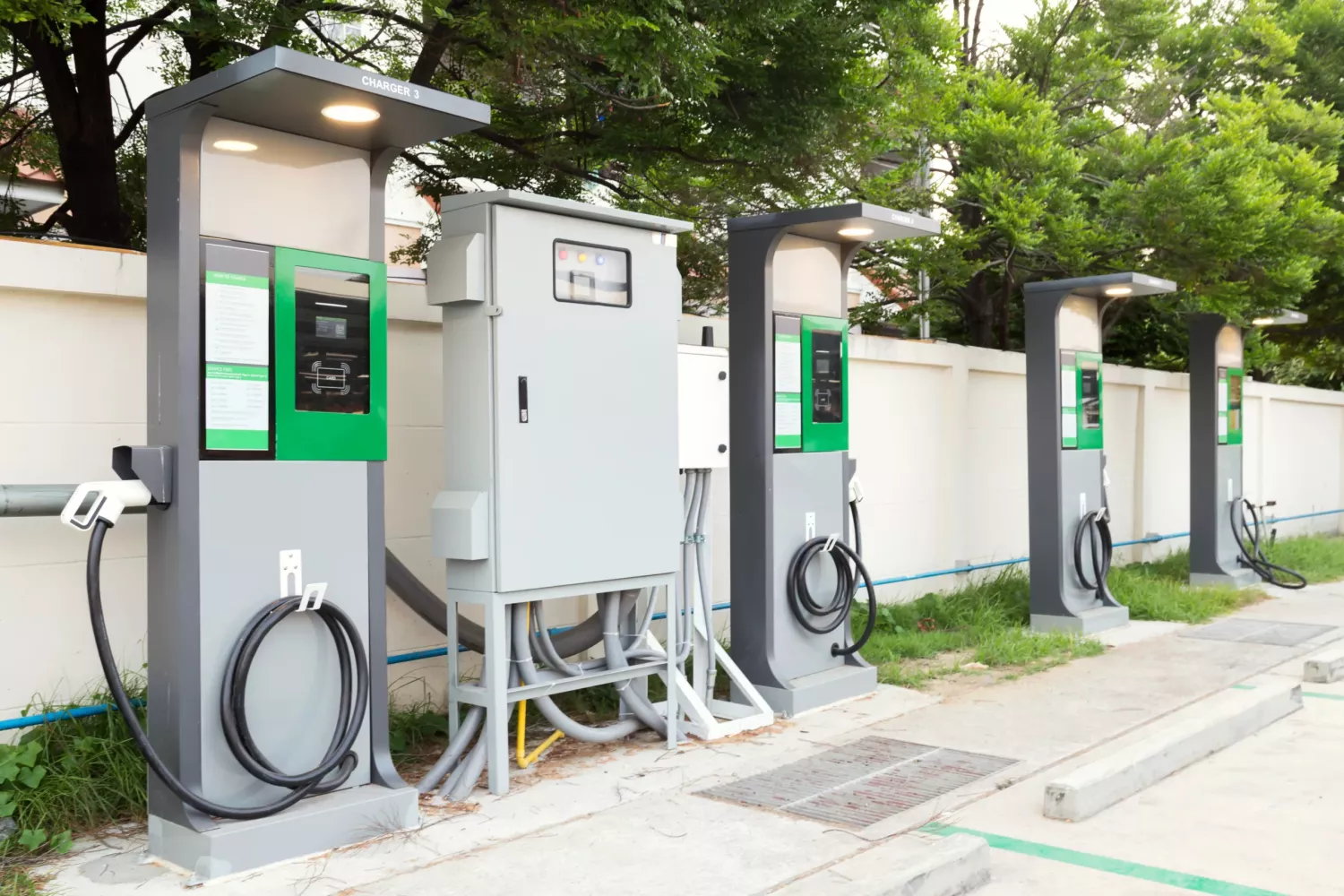 fast electric vehicle car charger with cable supply plugged and power supply box at EV station sites. EV car charging station in car park at supermarket ready to serve future automotive and city life.