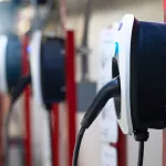 Electric car charging station for charge EV battery. Plug for electric vehicle. EV charger. Charging point at car parking lot of the mall. Clean and sustainable energy. Commercial EV charging point.