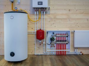 Heating boiler tank. Room with heating equipment. Gas boiler technologies. Heating system country house. Boiler tank at wooden wall. Gas equipment to maintain temperature. Engineering communications