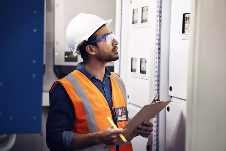 Man, engineering and clipboard in control room, box inspection and machine maintenance. Male electrician, system and electrical substation for power, industrial generator and technician checklist.
