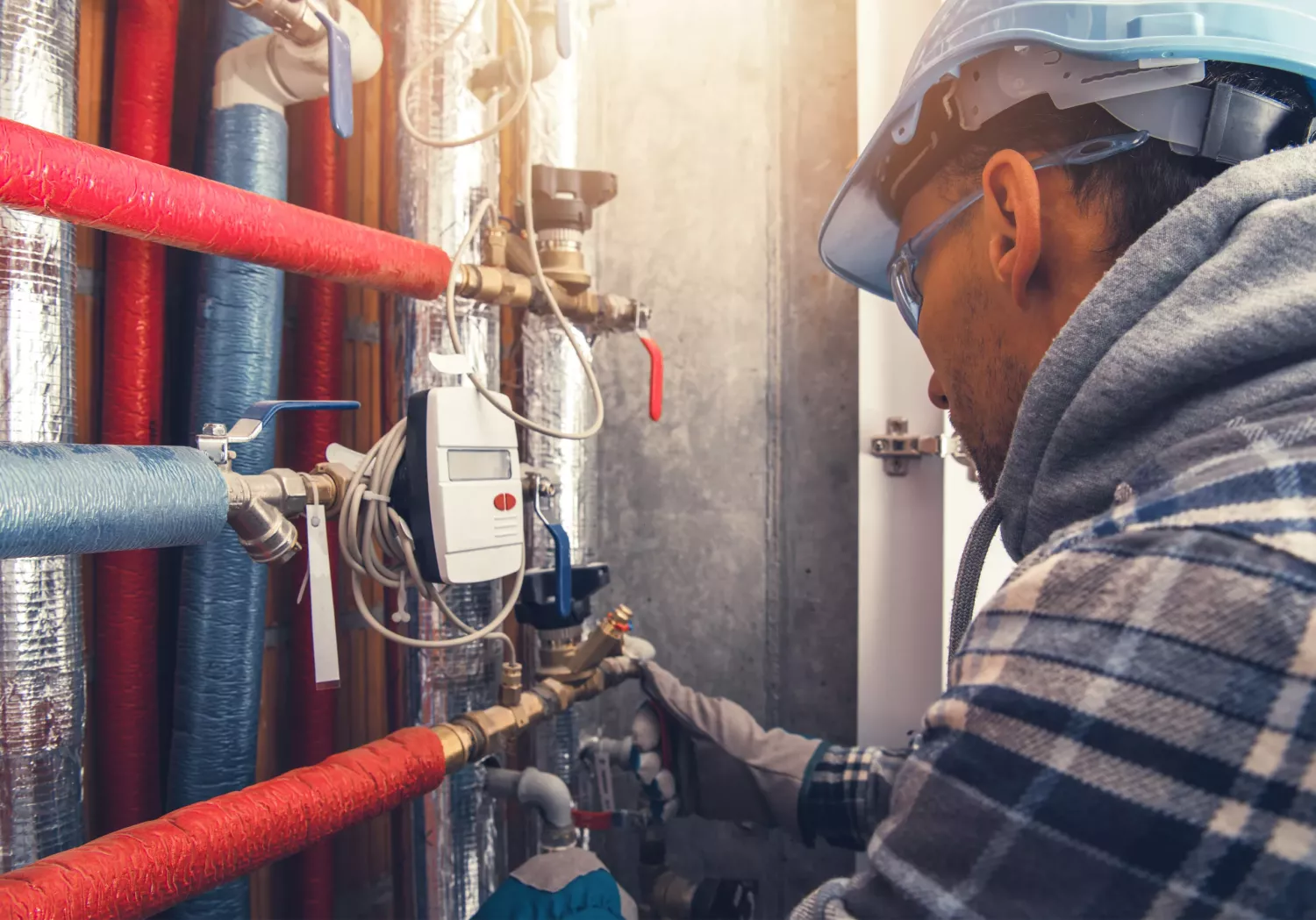 HVAC Heating Technician Making Final Check of the System. Checking All Hot Water Valves, Pipelines and Counters.