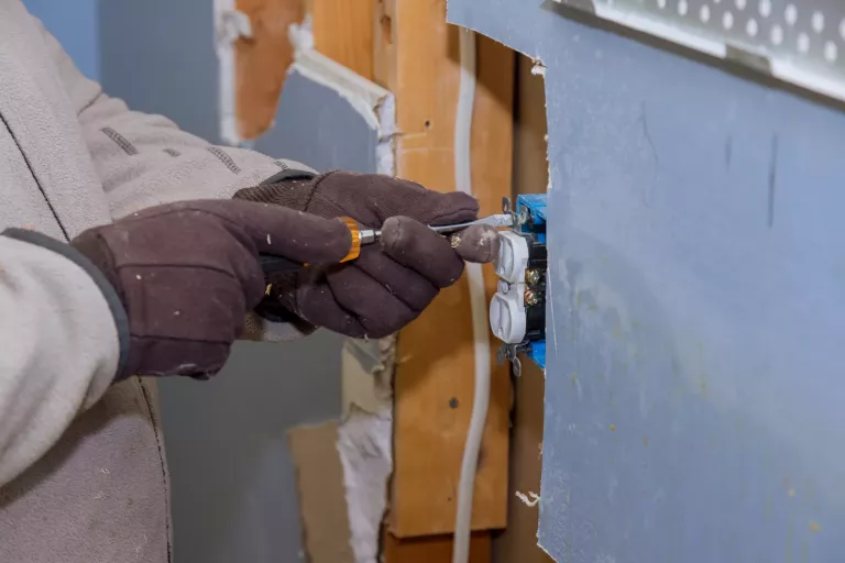 Preparing to remove an electrical outlet of the screws for electrical wires receptacle plug panel