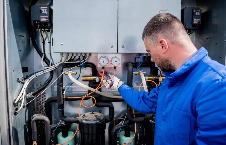 The technician checking power lines of the heat exchanger with current clamps.